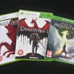 Three X Box disks of Dragon age to represent the RPG remakes and sequels