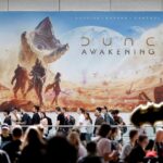 A promotional poster of Dune: Awakening in a gaming convention