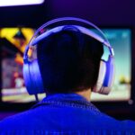 a man wearing headphones while playing Vampire: The Masquerade - Bloodlines 2 on his PC