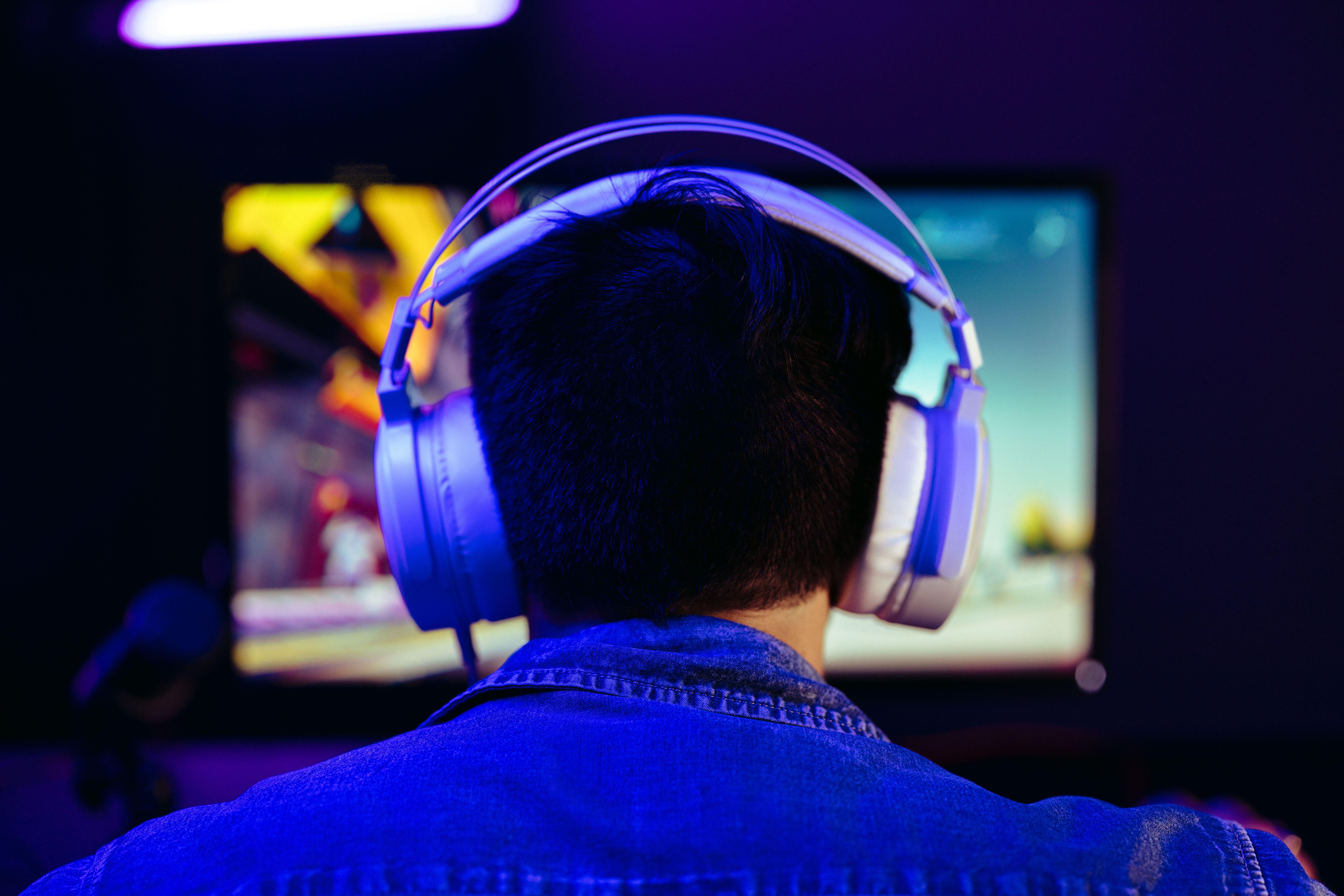 a man wearing headphones while playing Vampire: The Masquerade - Bloodlines 2 on his PC