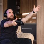 a man getting frustrated while playing Wuchang: Fallen Feathers on his console in the living room