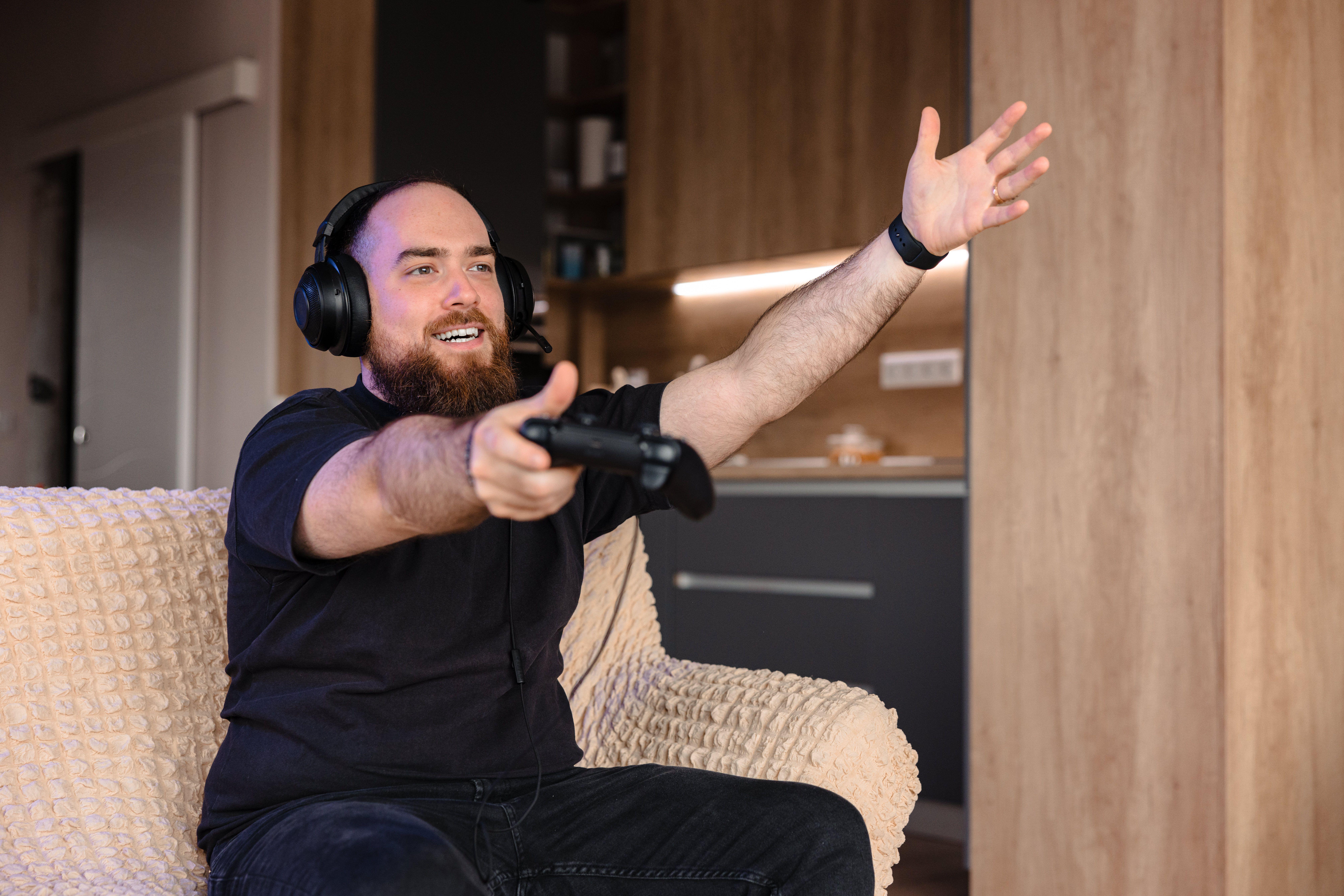 a man getting frustrated while playing Wuchang: Fallen Feathers on his console in the living room
